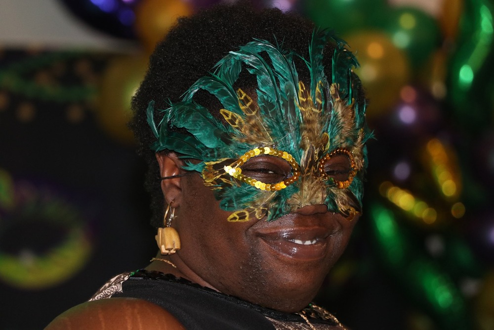 female with mardi gras mask on face 